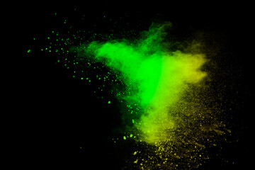 Abstract splash of green colored powder on black background.Green powder explosion.