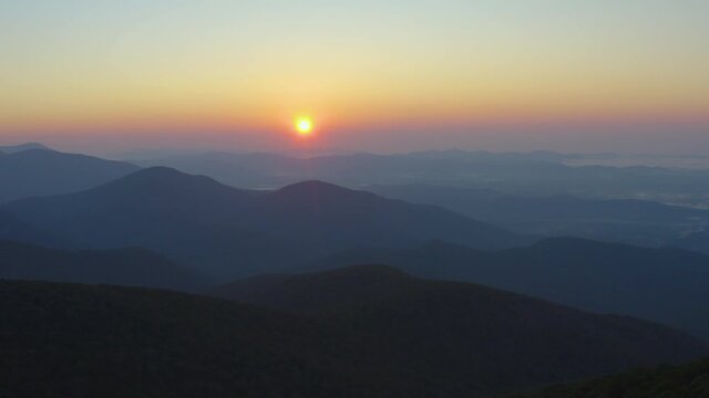 An aerial shot (dolly out) of the sunrise as seen from the summit of Mt. Pleasant, located in the Mount Pleasant Special Management Area of the George Washington National Forest in Virginia.