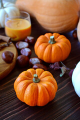 autumn layout for Thanksgiving and Halloween. harvest. composition of white and orange pumpkins of different sizes. cinnamon sticks, chestnuts, candles, wooden table
