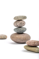 Studio photo of stacked, natural stone pebbles isolated on white background with soft shadow.
