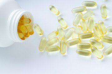 Omega 3 capsules and bottle on white background. Health support, vitamins and treatment.