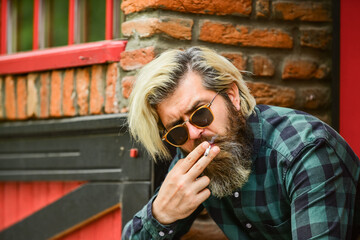 Obraz premium start new day. secondhand or passive smoke. brutal caucasian male in glasses. Man Smoking Outdoor. Fashionable mature man smoking cigarette. Punk hipster man smoking. Smoking and habit