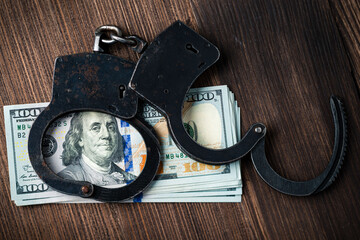 handcuffs and dollars bills