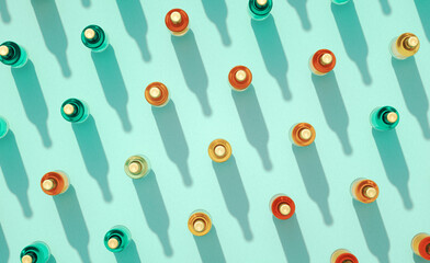 Top view of many closed glass beer bottles mockups standing on turquoise blue background.
