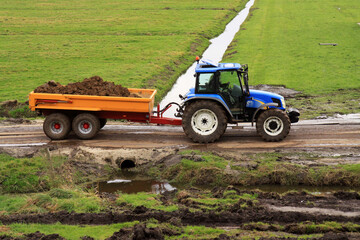 Tractor with tipper trailers transports a load of clay over metal drive plates.  