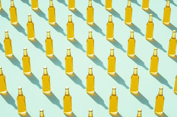 Rows of full beer bottles against light blue surface.
