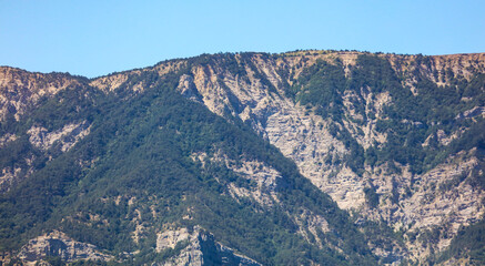 Fototapeta na wymiar Peaks of rocky mountains against a blue sky.