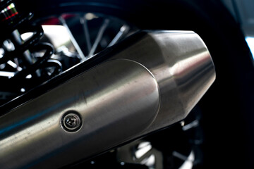 Close up beside of exhaust pipe on aluminium surface of motorcycle.