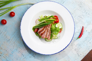 salad with duck and herbs in a plate