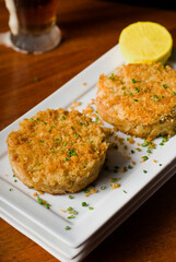 Crab cake served w/ spicy rémoulade sauce on top of a mixed green salad. Jumbo crab meat mixed w/ garlic, onions, spices & fried in butter. Classic American restaurant appetizer.