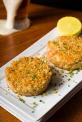 Crab cake served w/ spicy rémoulade sauce on top of a mixed green salad. Jumbo crab meat mixed w/ garlic, onions, spices & fried in butter. Classic American restaurant appetizer.