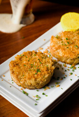 Crab cake served w/ spicy rémoulade sauce on top of a mixed green salad. Jumbo crab meat mixed w/ garlic, onions, spices & fried in butter. Classic American restaurant appetizer.