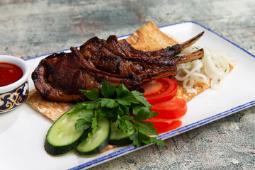 rack of lamb in a plate with fresh vegetables