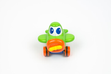 Small green toy airplane with eyes. Children's toy on a white background.