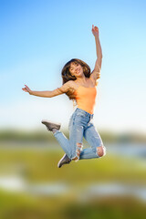 girl jumps on a blurry background on a clear sunny day