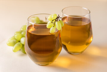 Two Glasses of Tasty Grape Juice on Yellow Background Healthy Drink Raw Green Grape Horizontal