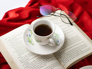 Black tea/coffee on a book with red cloth stock image.