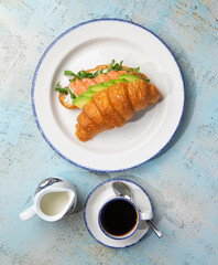 croissant with salmon and avacado in a plate