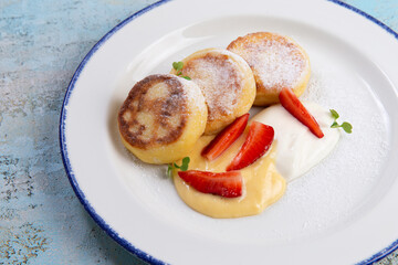 Cheesecakes traditional Russian food served with fresh berries,