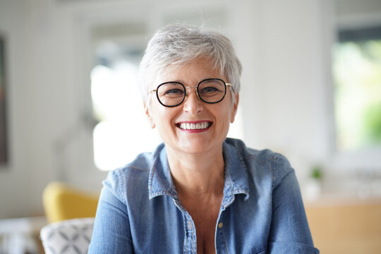 portrait of a beautiful smiling 55 year old woman with white hair