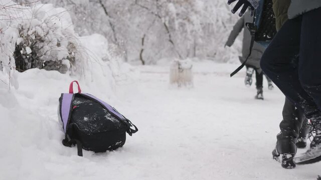 Teen girls after school in the winter fun near school. Close-up of the backpacks that Schoolgirls take it and run away out of frame.