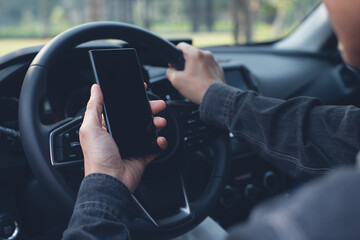 Mockup of man using blank screen mobile smartphone searching location while driving a car 