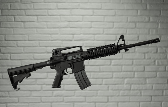 American army rifle M4A1 against a brick wall