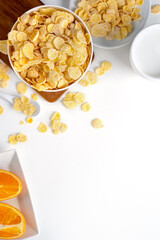 Top view of corn flakes bowl with milk on white background.