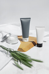 Bottles, tubes, jar of cream or lotion with white towel, herbs and wood on a white background. Organic cosmetic. Treatment spa beauty skincare healthcare. Brand commercial. Product. Mock up