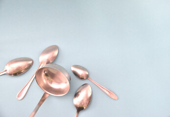 Tablespoons laid out next to a ladle on a light background.