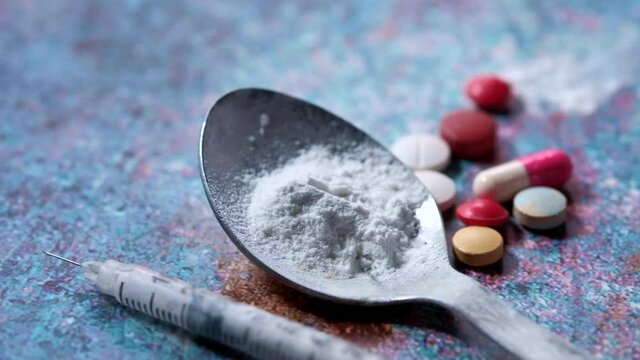 drug addiction concept with heroine packet and syringe on black backgrund 