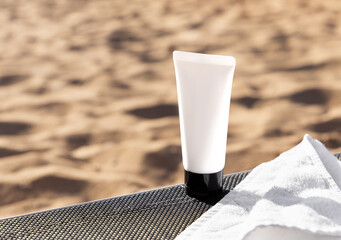 Sun protection cosmetics. Body lotion or cream with UV protection and moisturizing effect on sandy beach background. Packaging design. Cosmetics mock up. White tube cream. Healthy sunbathing. Natural