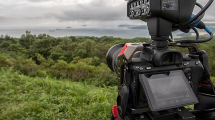 close-up of a camcorder filming summer landscapes
