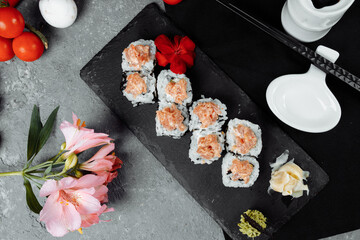 Felix roll with tuna wasabi sauce and pickled ginger on a black board