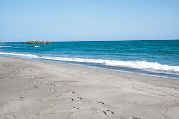 波打ち際の海と砂浜の足跡