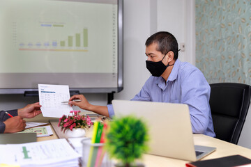 Naklejka premium Businessmen wearing protective masks discussing and work together in meeting room. Social distance practice prevent coronavirus COVID-19.