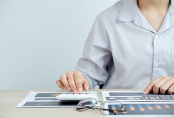 businesswomen bookkeeper use calculator and laptop doing account for paying tax on white desk in working office