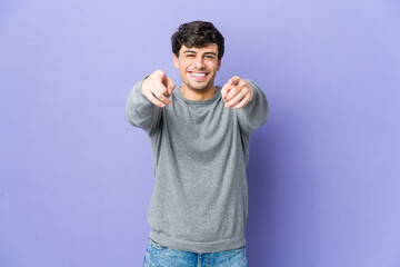 Young cool man cheerful smiles pointing to front.