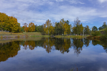 Obraz premium colorful trees and a river in a morning Symmetry reflections on the water. 
