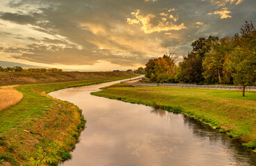 Fluss mit Spiegelung an einer Landstraße