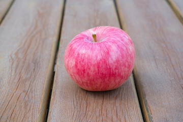 red Apple on a wooden table close-up