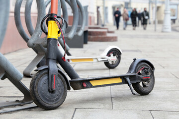 Electric scooters in a row on the parking lot. City bike rental system, public e-scooters on the street