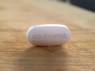 Adalimumab pill on Wooden Table