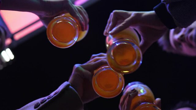 Close-up Hands take Four Glasses of Beer on a Night Street