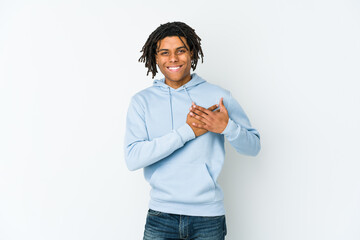 Young african american rasta man has friendly expression, pressing palm to chest. Love concept.