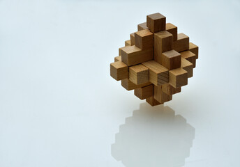 Wooden Puzzle with reflection on white surface - background.