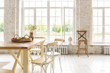 Large spacious room with a trendy loft design of sitting area. huge windows and stylish wicker light furniture inside. an abundance of ethnic decor