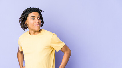 Young african american rasta man looks aside smiling, cheerful and pleasant.