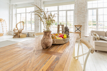 Large spacious room with a trendy loft design of sitting area. huge windows and stylish wicker light furniture inside. an abundance of ethnic decor