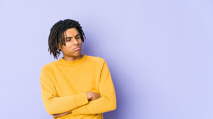 Young black man wearing rasta hairstyle tired of a repetitive task.
